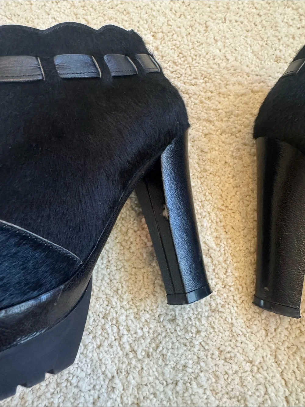 ZORAIDE black calf hair ankle booties with leather strap and tassel accents.